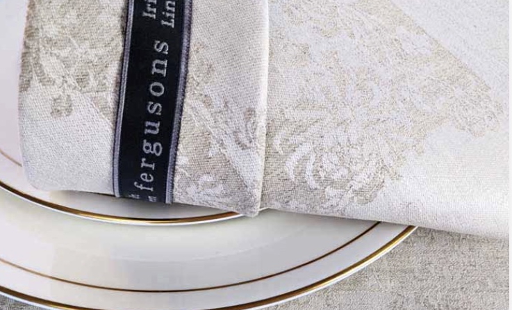 White Irish linen place setting on plate with golden accent.  Courtesy of Thomas Ferguson