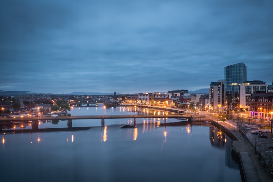 Irish Expressions, Irish sights - city of Limerick at night. River with a bridge, city light reflections on the water.