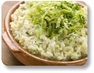 Irish colcannon.  In a brown bowl with shredded cabbage topping.