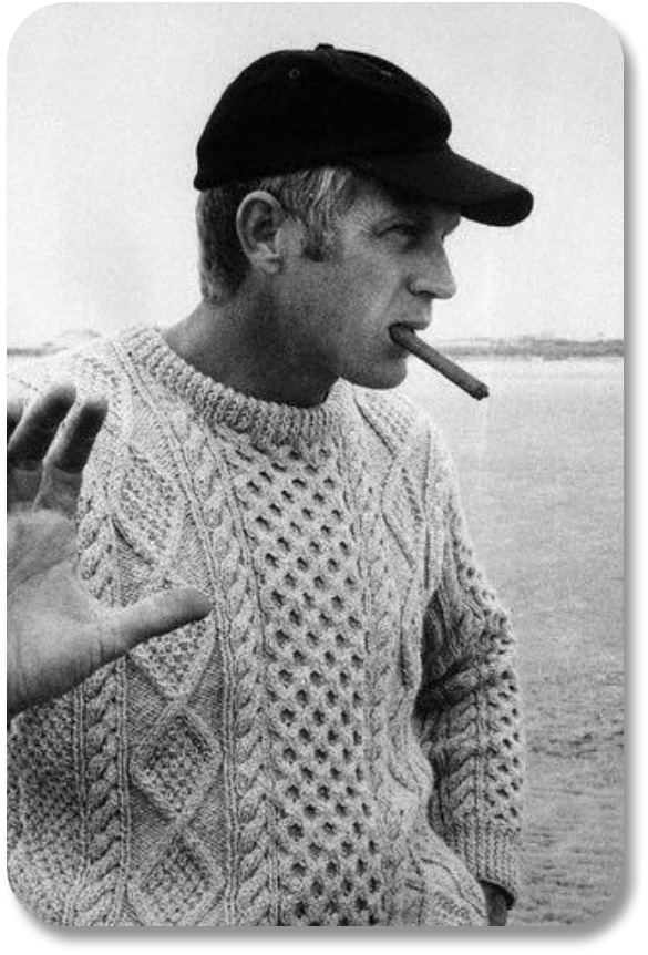 Paul Newman smoking a cigar wearing an Aran sweater (and not happy about being photographed.)