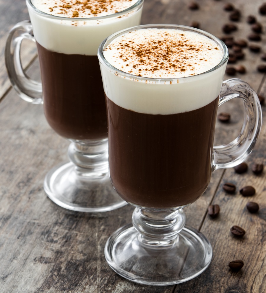 Image of two perfectly formed Irish Coffees in glass mugs with sharp distinction between cream and coffee.