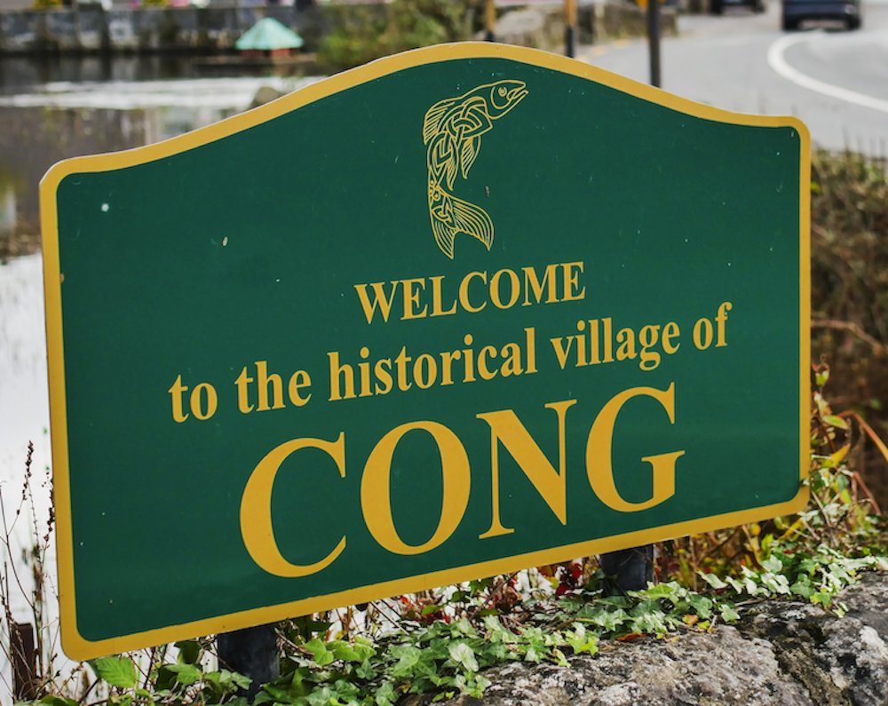 A green and yellow sign saying Welcome to the Historical Village of Cong